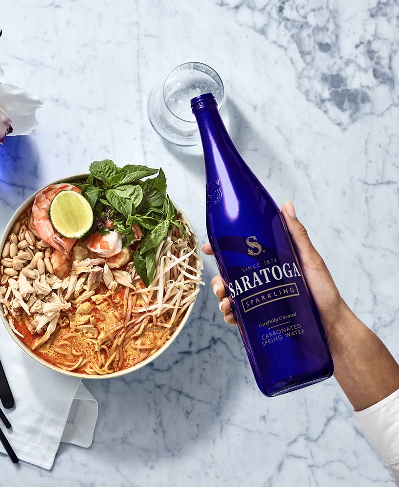 a bottle of saratoga water with a noodle dinner